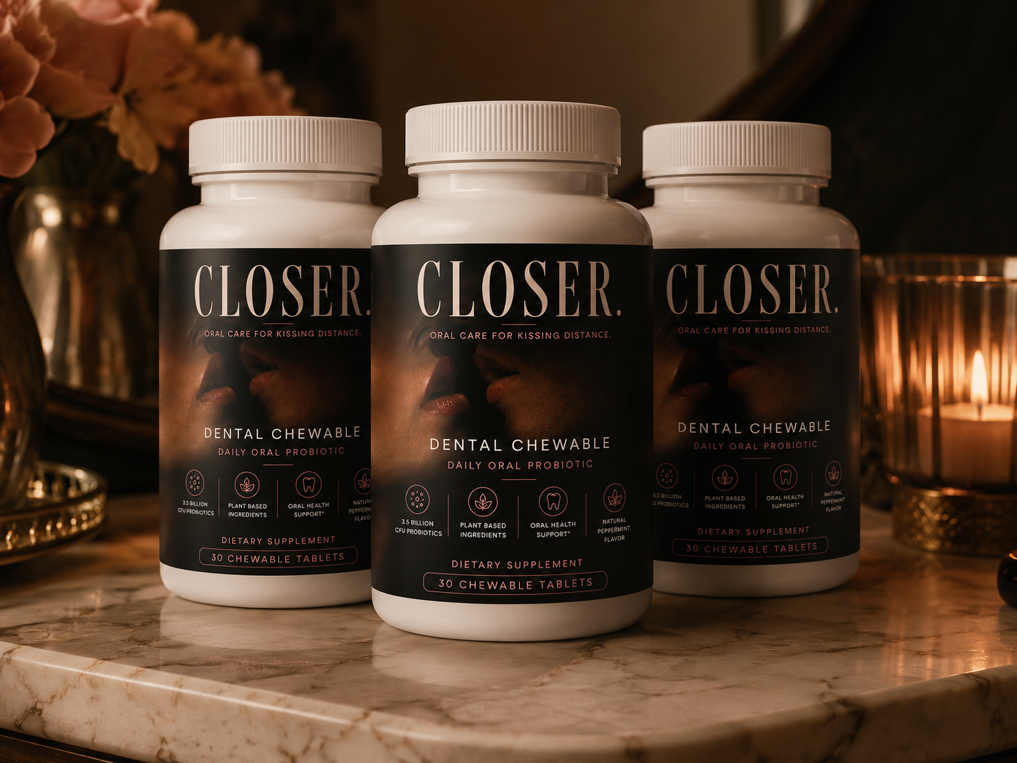 Three bottles of CLOSER. daily oral probiotic on a marble counter in candlelight