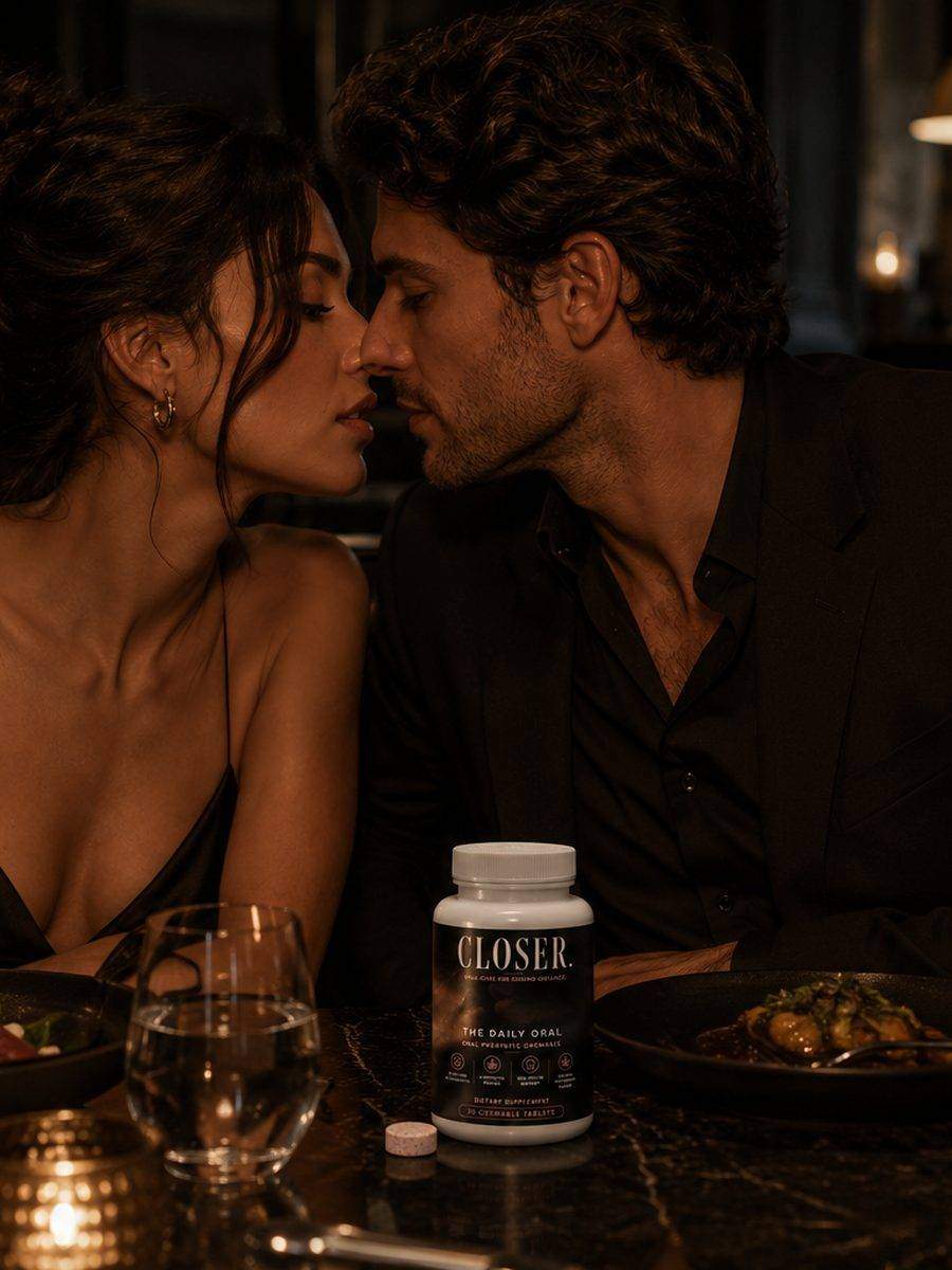 Attractive couple leaning in across a dark restaurant booth, drinks on the table