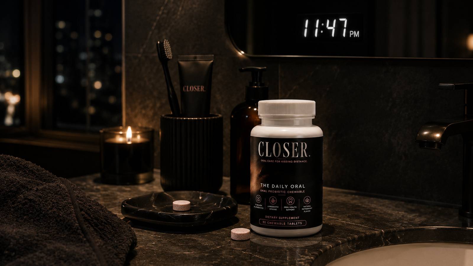 CLOSER. bottle on a marble bathroom counter at 11:47 PM beside toothbrush, floss and a lit candle